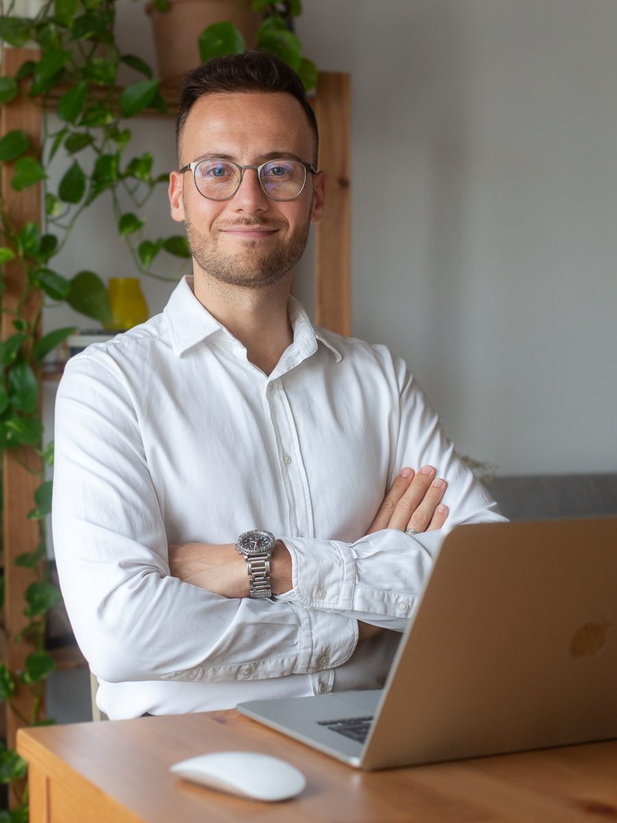 Dorian López, fundador de Raíces Financieras, sonriendo frente a su portátil